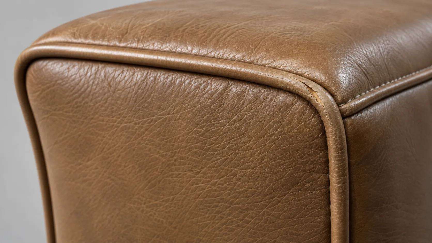 Worn piping on the front corner of a tan seat cushion