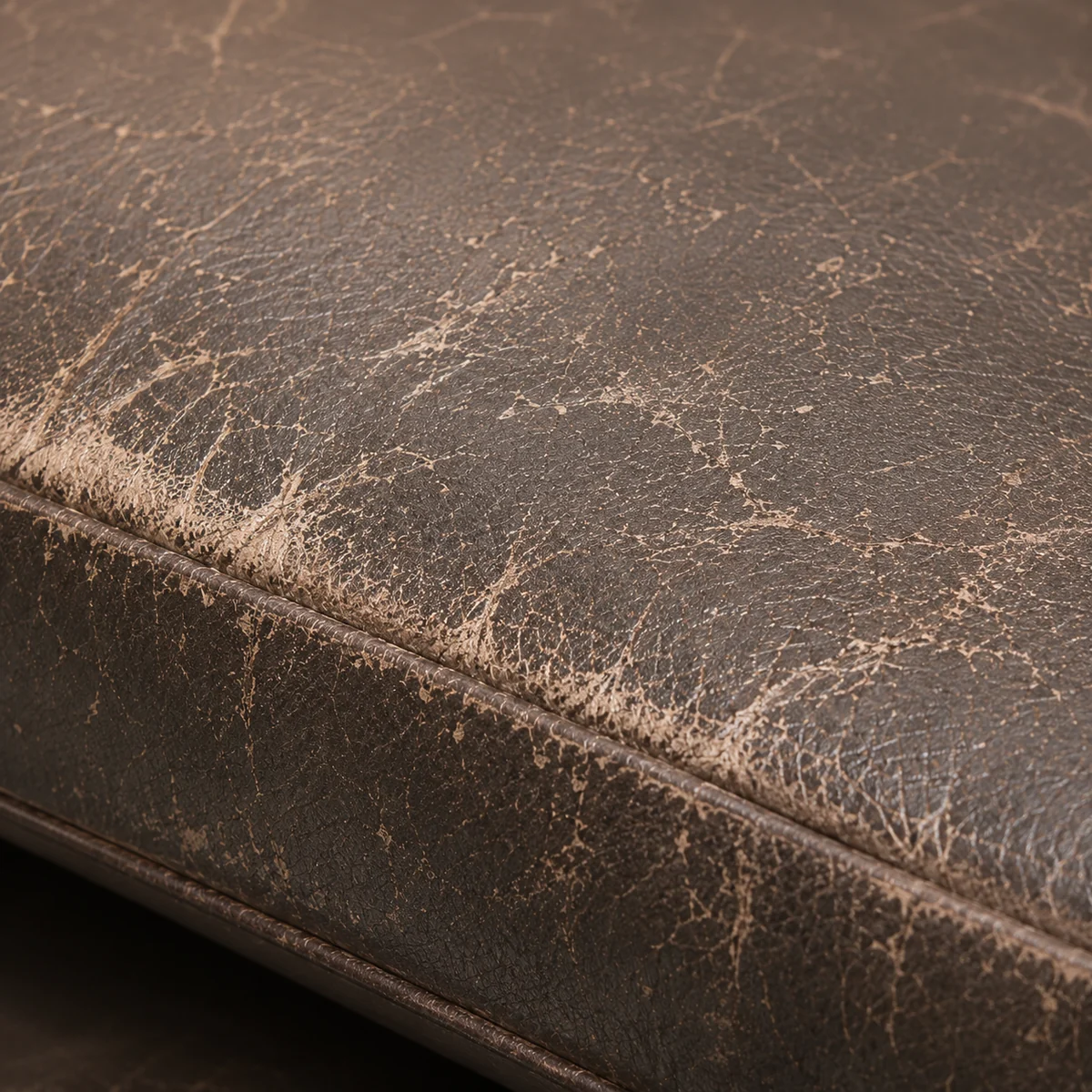 A faded, worn edge on brown dental seat vinyl