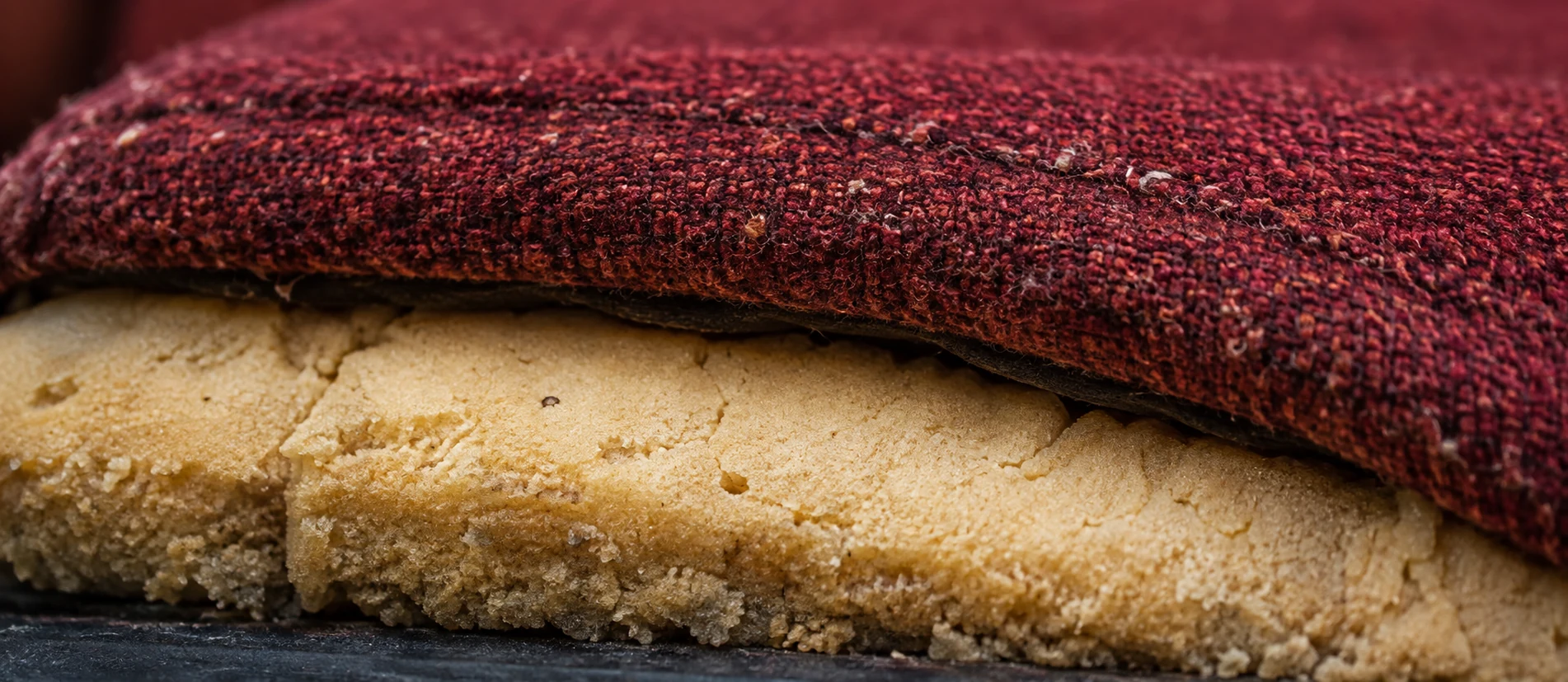 Flattened theater seat foam under a worn fabric cover