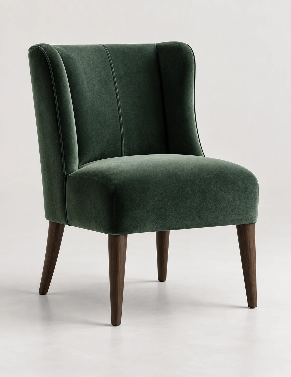 Green velvet accent chair with a shaped wing back on dark tapered legs