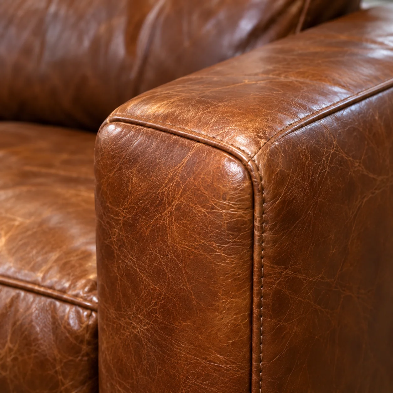 The same leather armrest after repair, the scuffing gone