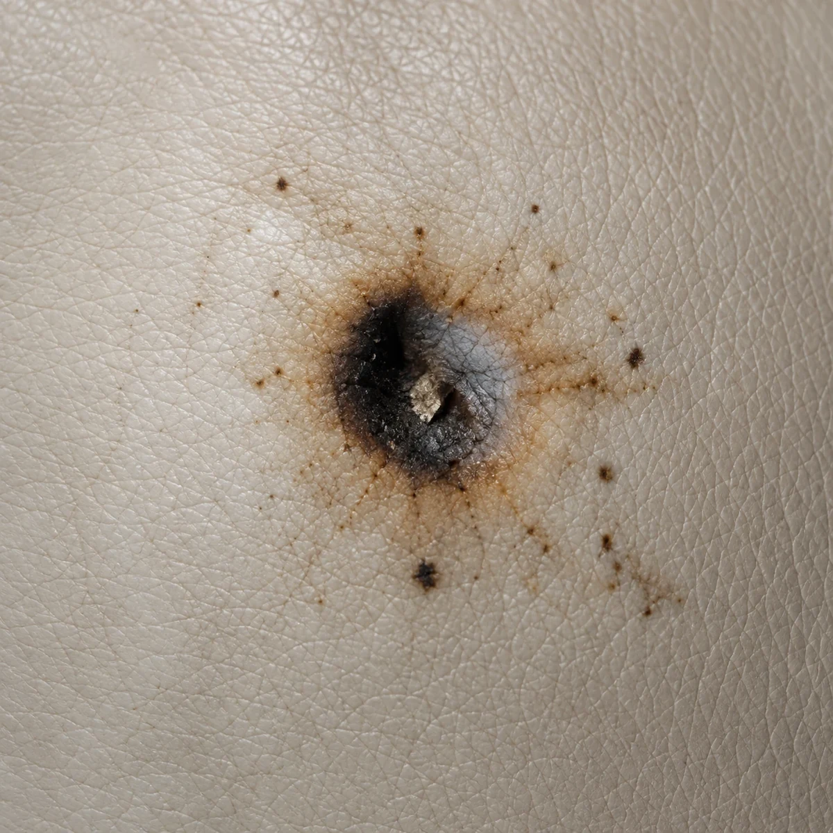 Small burn mark on pale leather