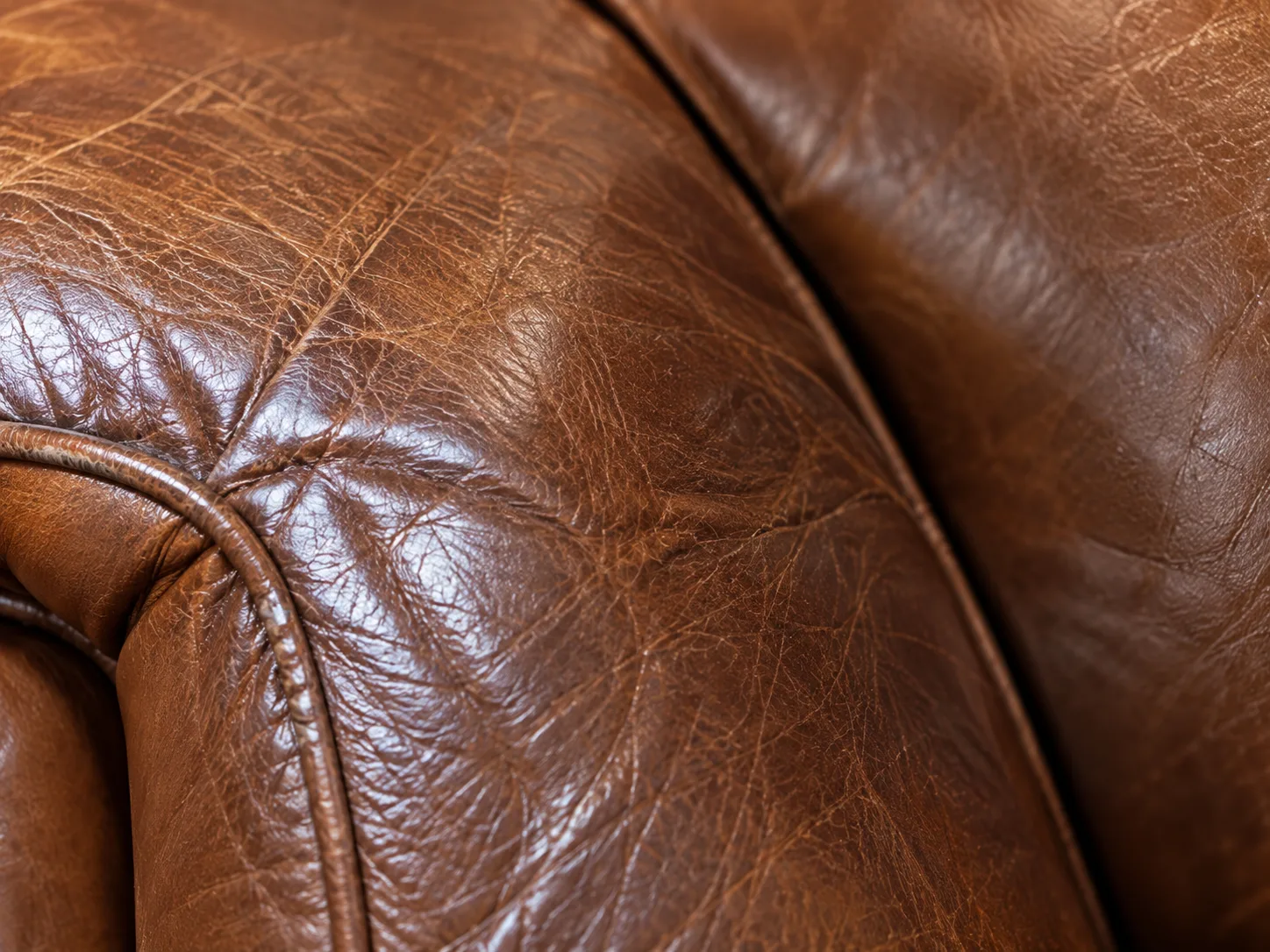 Close view of creased and dried leather on a seat cushion