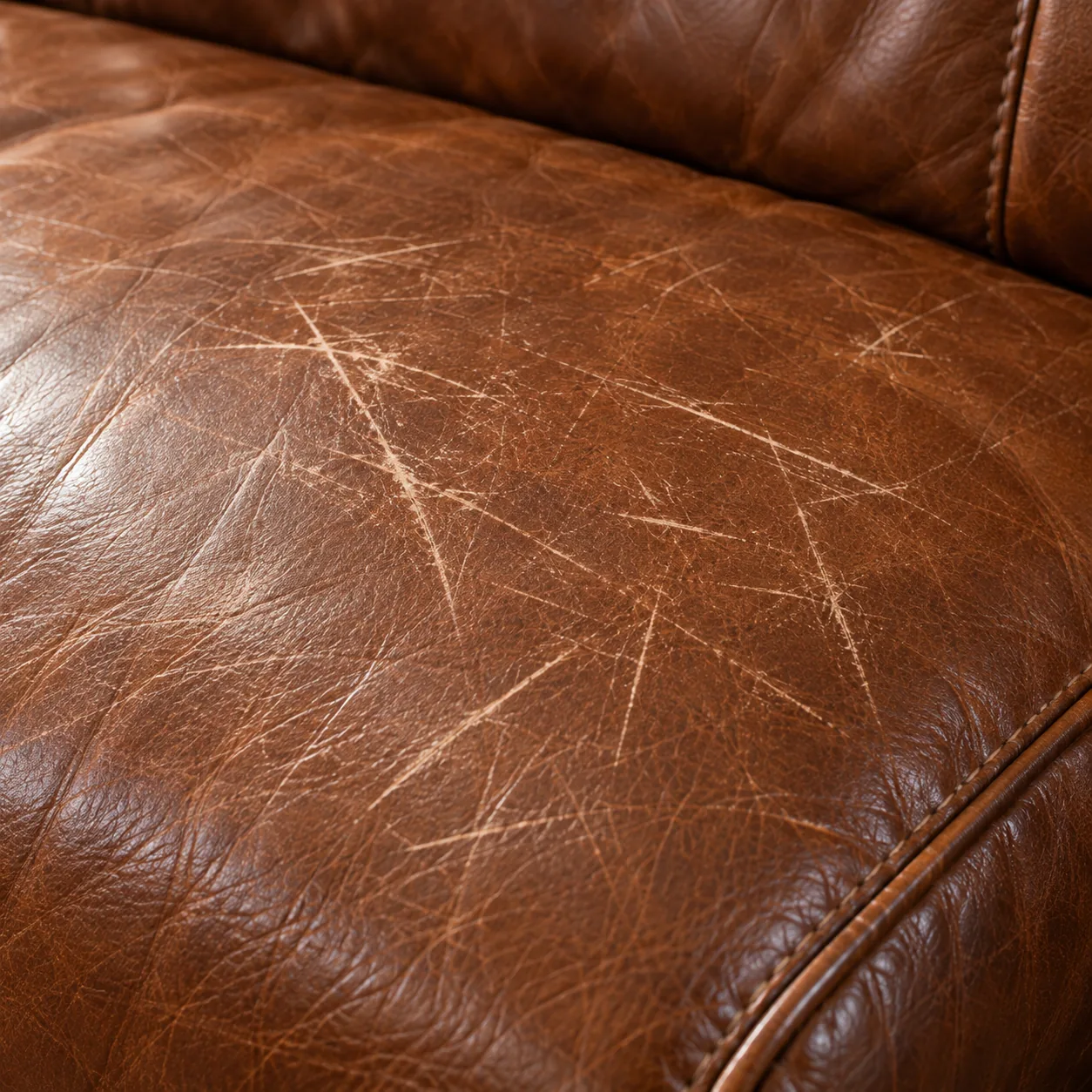 Fine scratches across a cognac leather couch seat