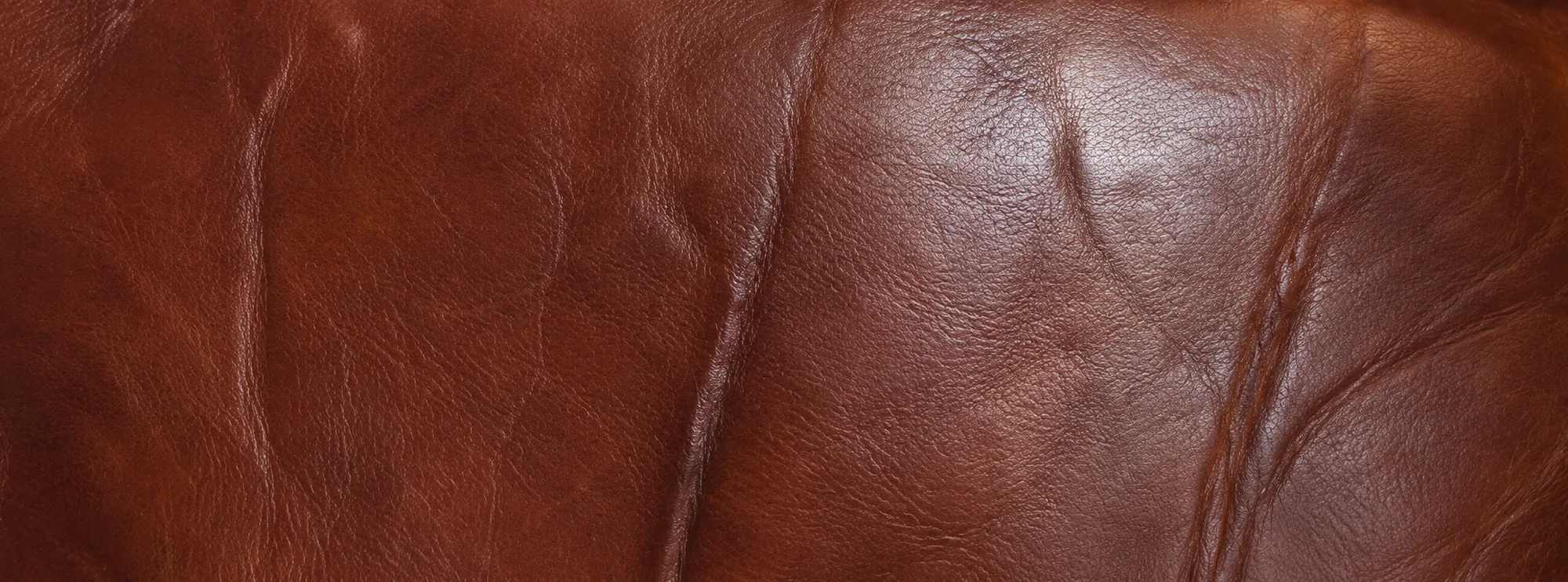 Worn front edge of a leather seat cushion on commercial seating