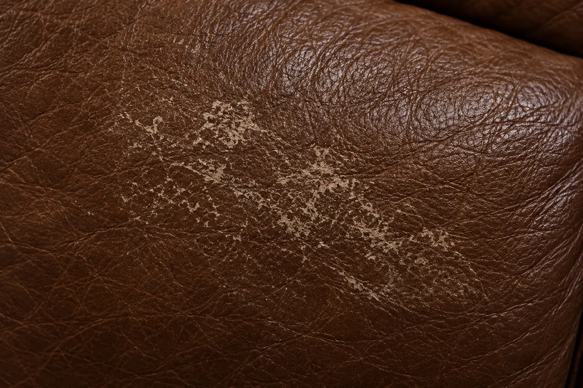 Pale scuffed patch on brown leather