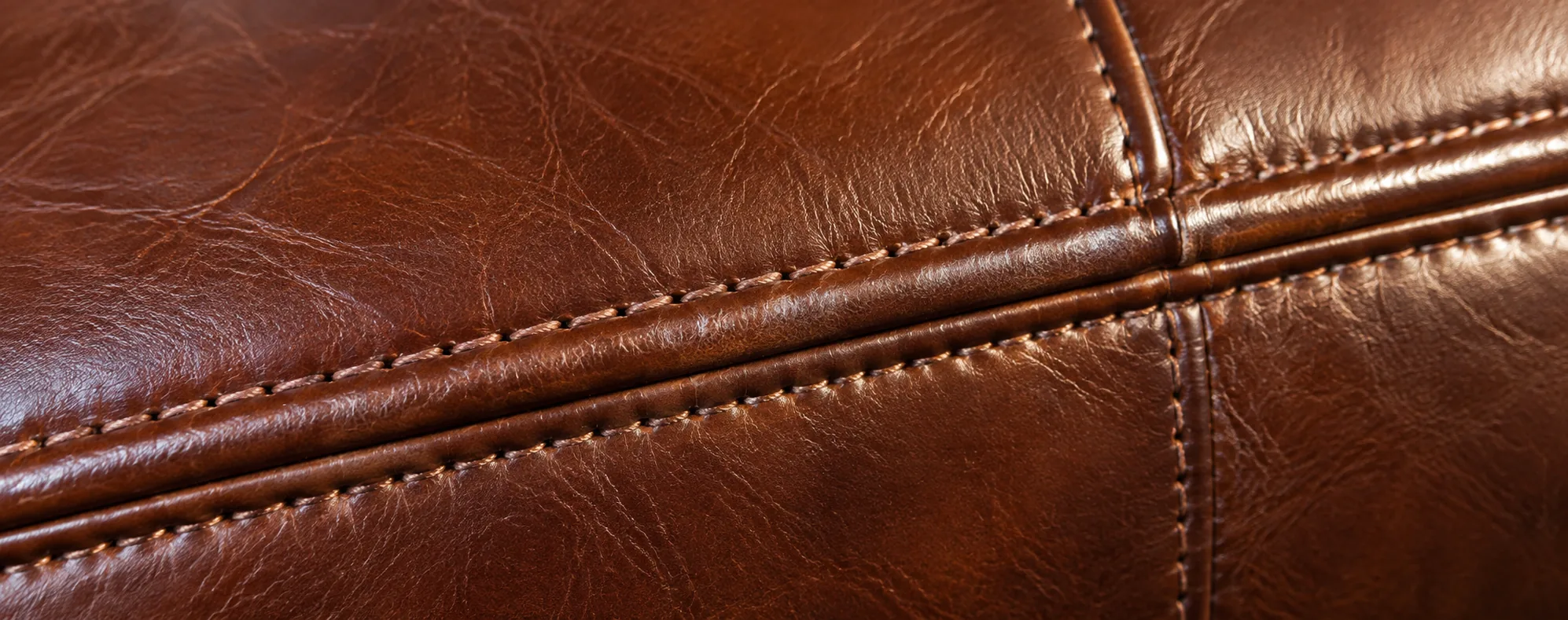 Close-up of restored stitching on a brown leather seat in a managed property
