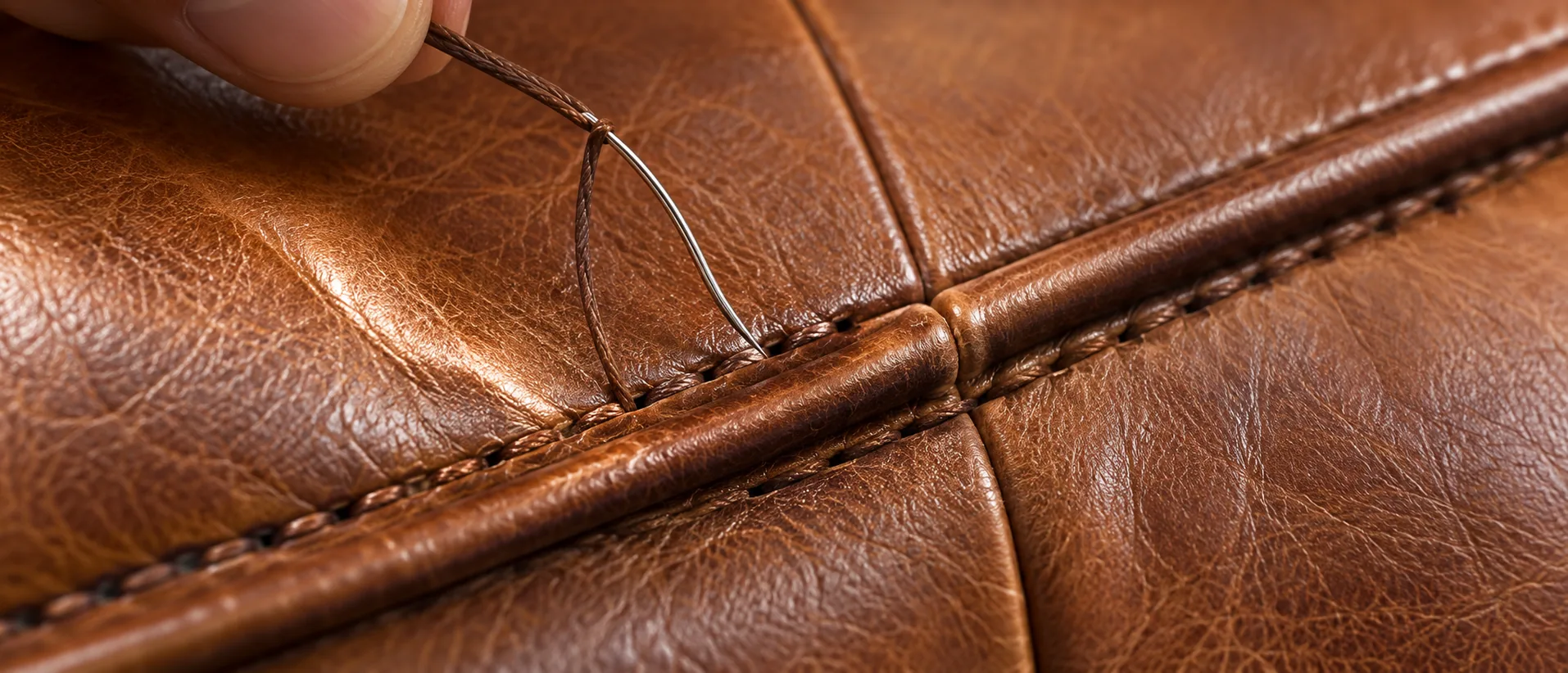 Close view of a leather seam being restitched early, before the panel opens