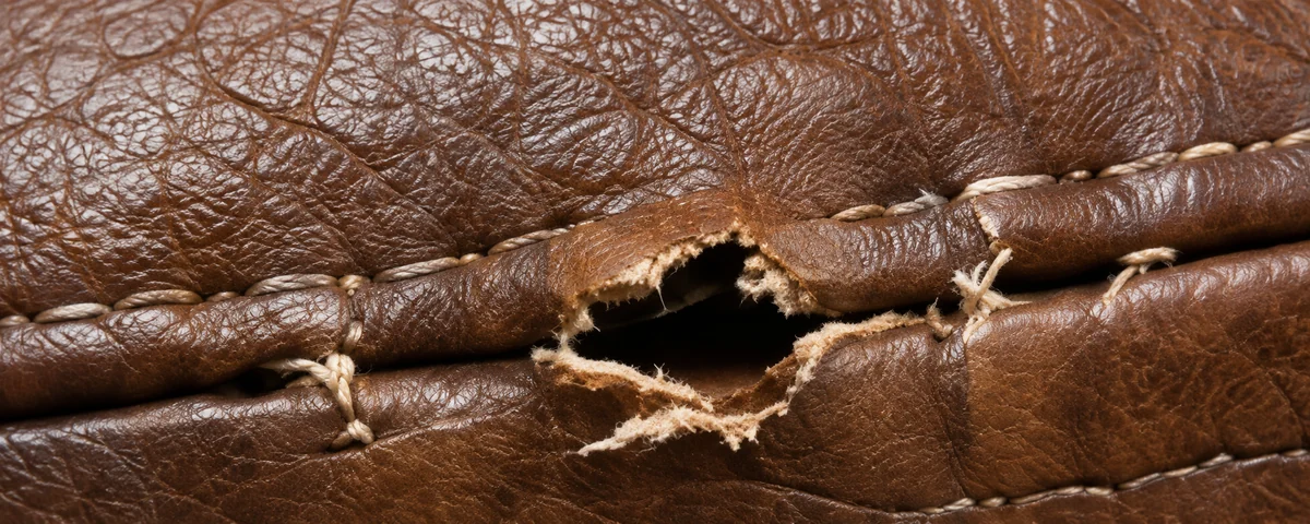Leather torn along a row of stitch holes