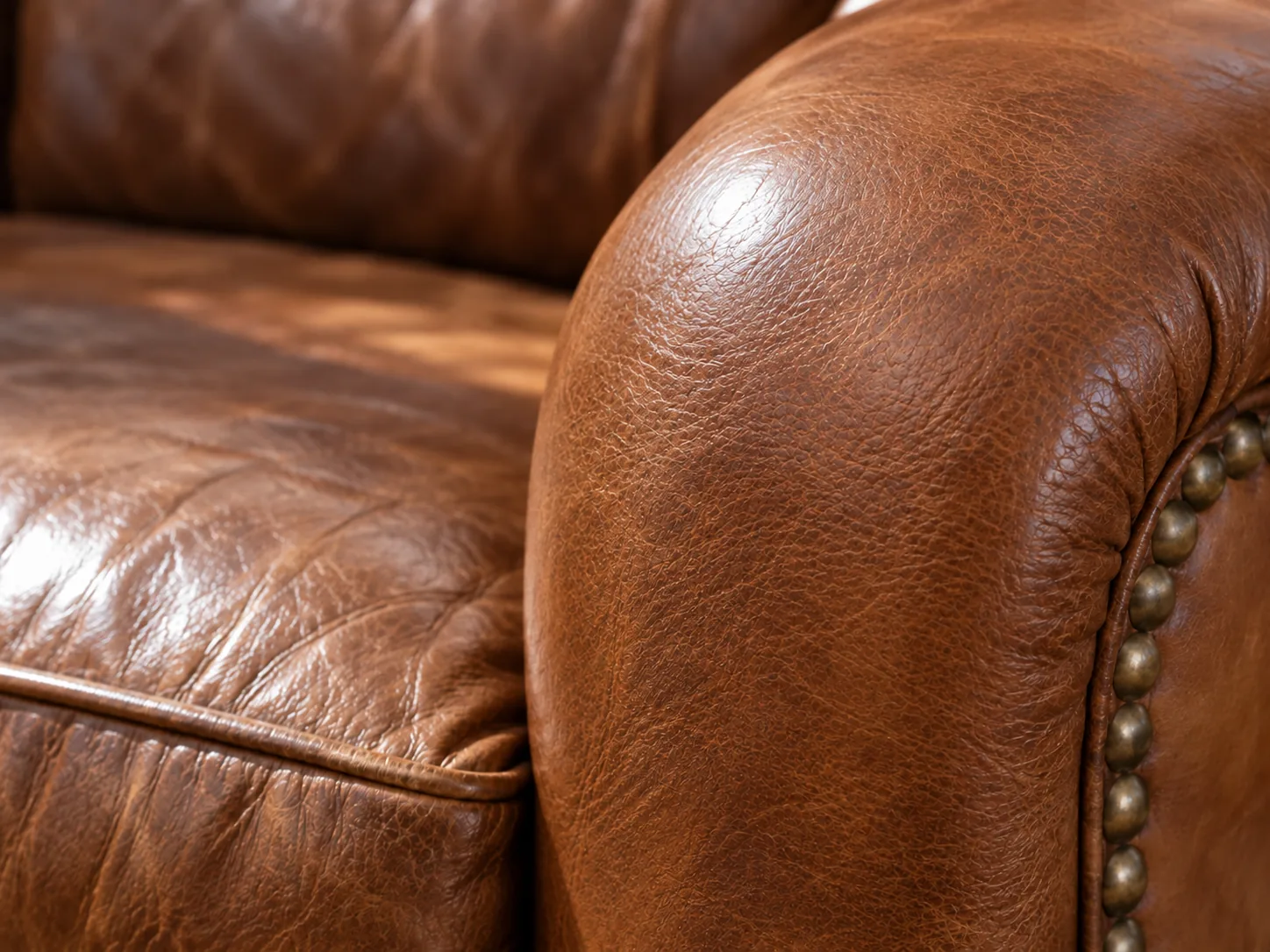 The same leather sofa arm after repair, smooth and even