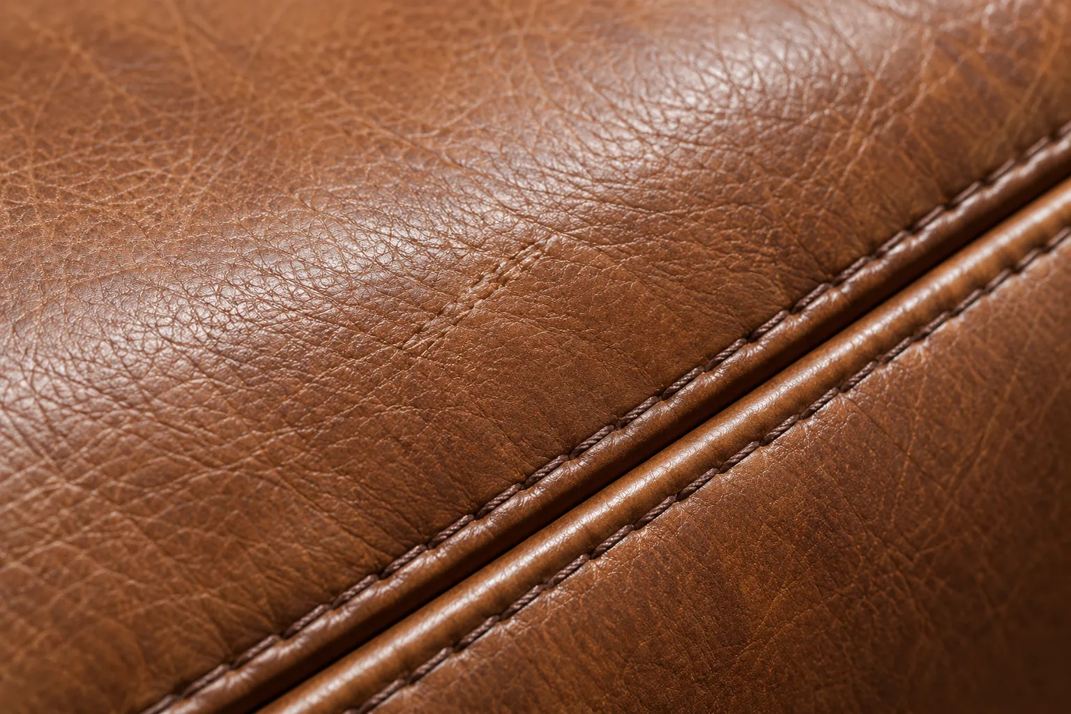 Close-up of a double-stitched seam on restored tan leather