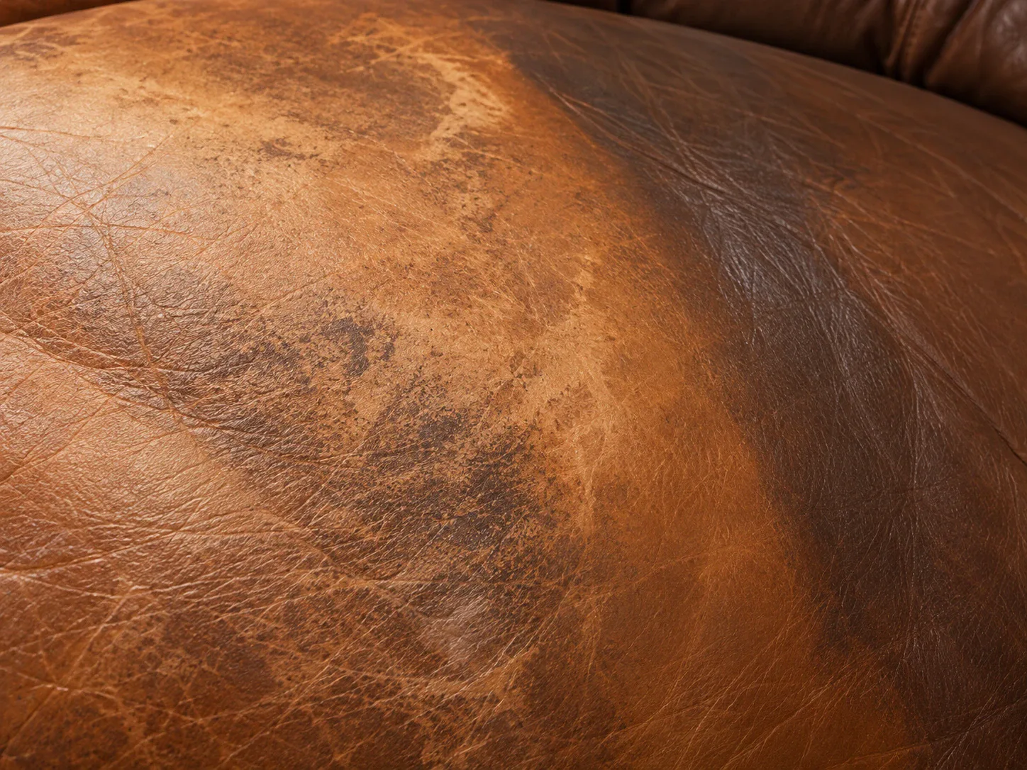 A sun-faded band of lighter color across brown leather upholstery