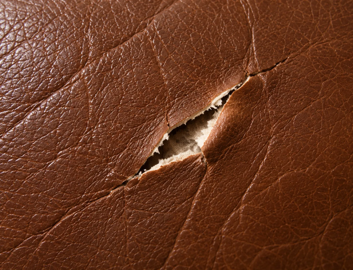 Tear in brown leather with clean edges