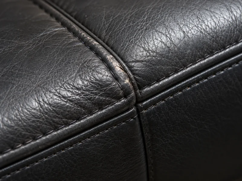 Technician blending color into a worn area of a leather armrest