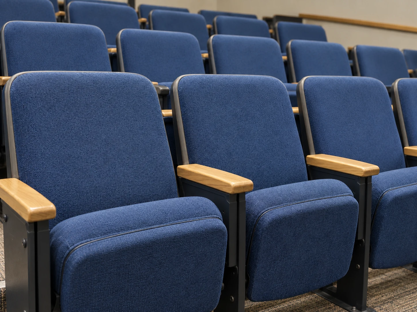 After: the same lecture hall seats recovered in clean navy contract fabric