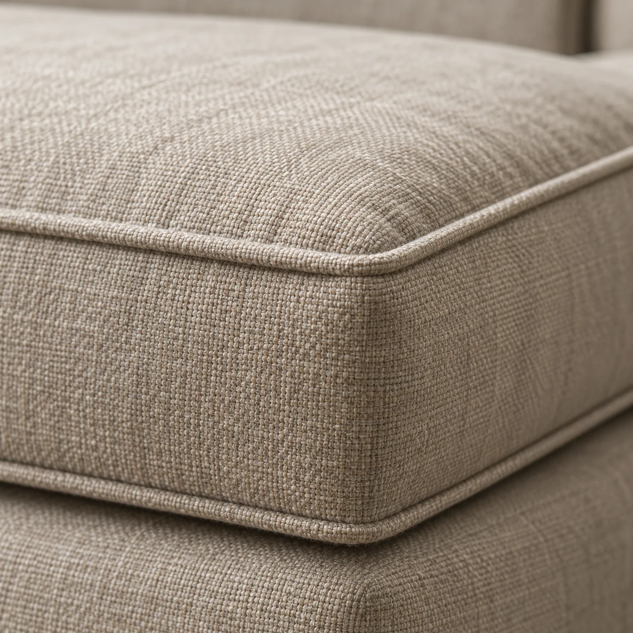 Corner of a linen boxed seat cushion showing the welted edge and boxing band