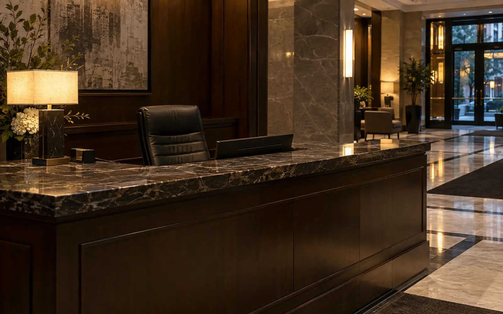 A black leather chair behind a building lobby concierge desk
