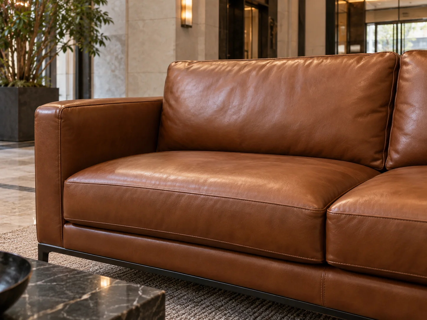 The same leather lobby sofa after restoration, ready for residents