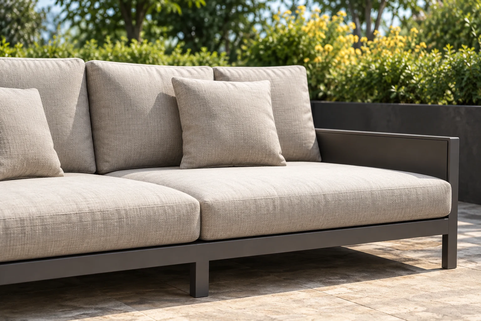 Long outdoor sofa with a dark frame and beige box cushions