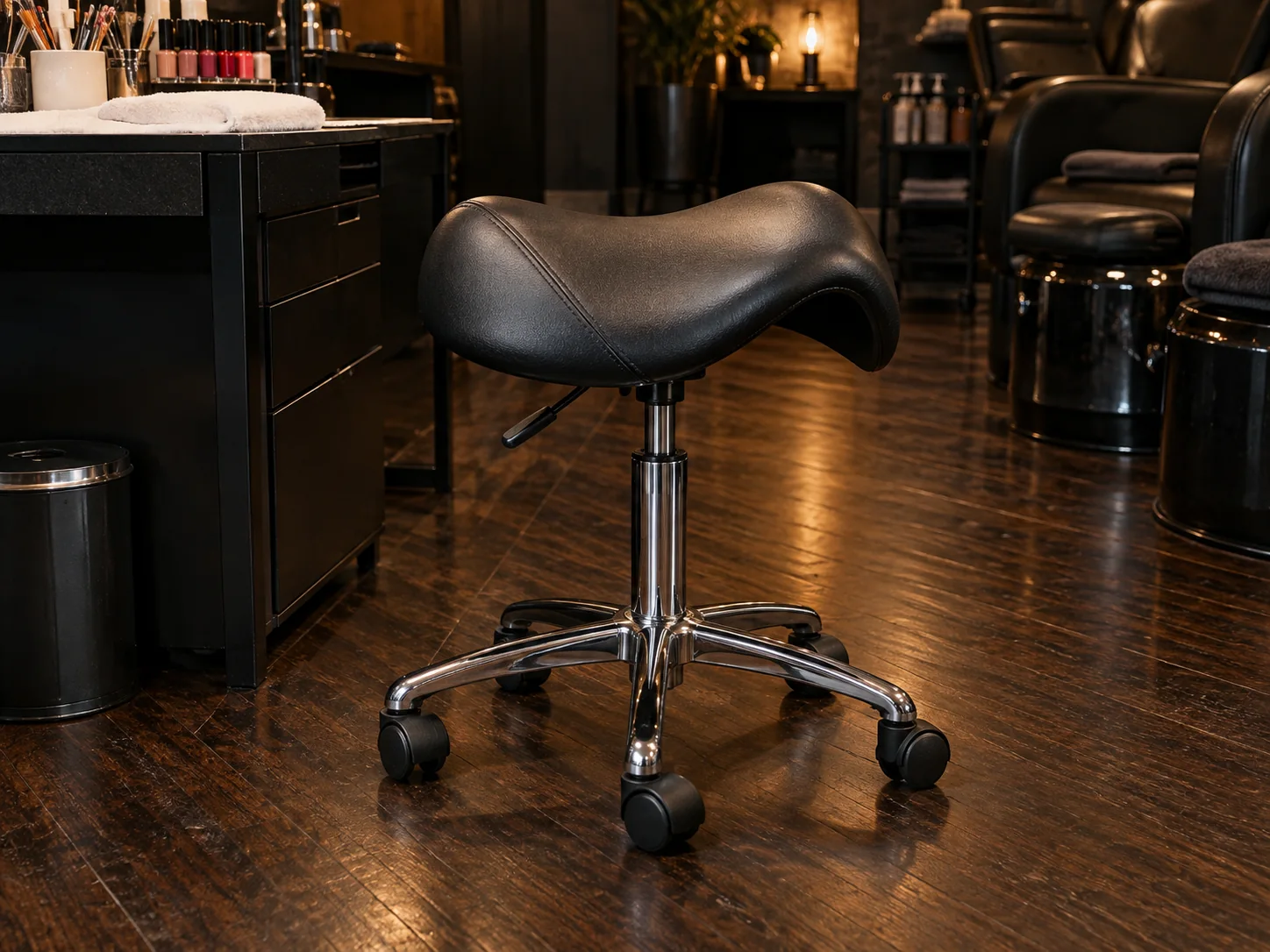 A saddle manicure stool seat on its gas cylinder and five-star base