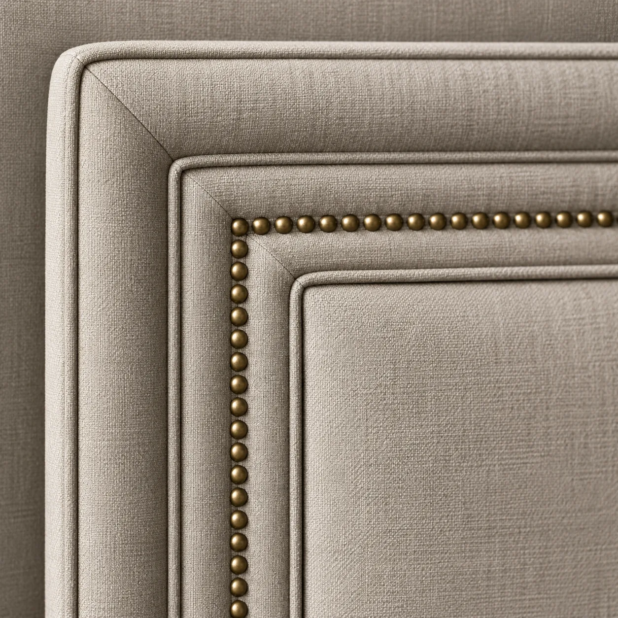 Stepped border with a double welt and antique brass nailheads on a linen headboard corner