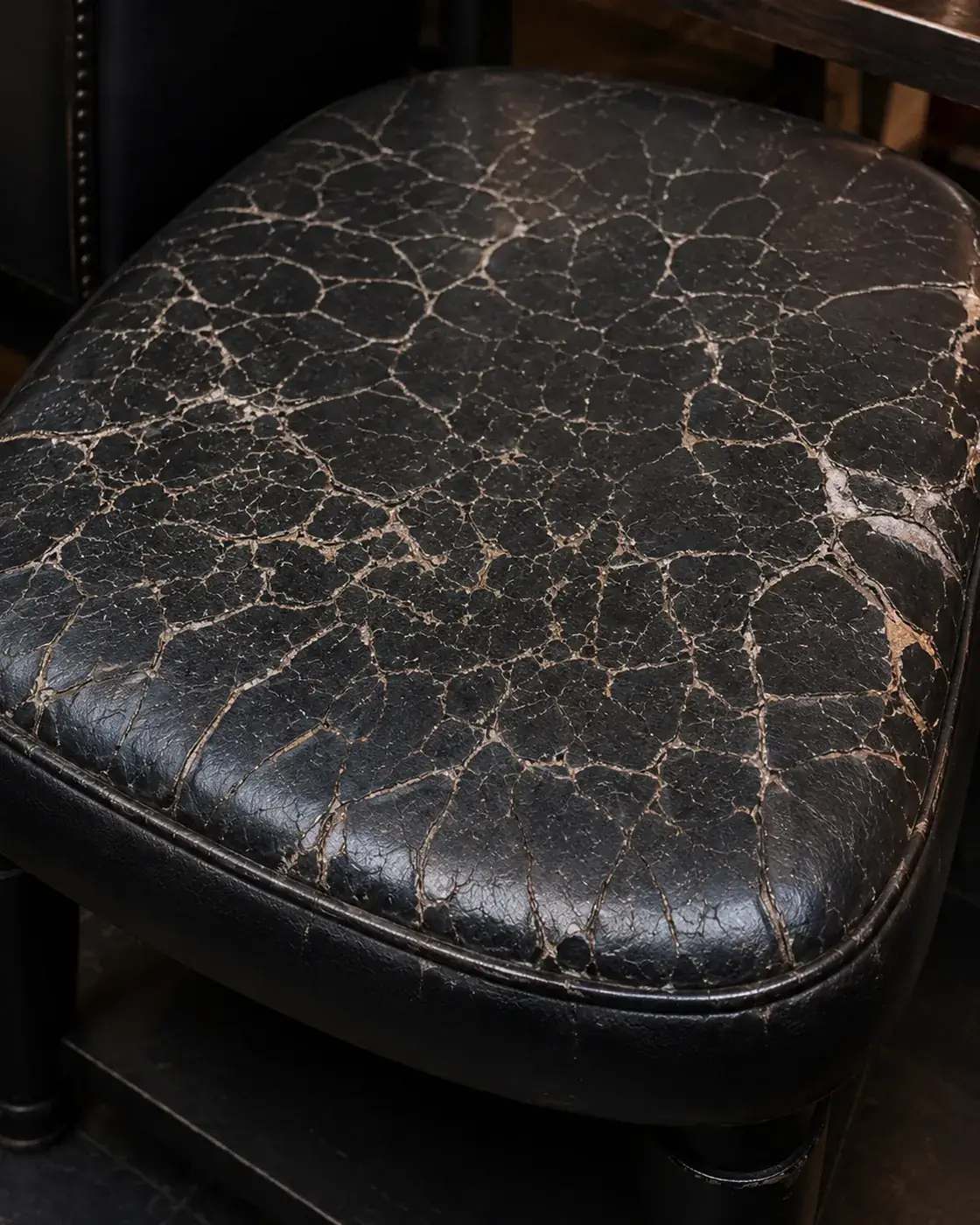 A nightclub ottoman seat with the finish crazed across the whole top