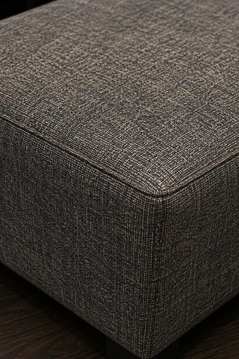 A charcoal woven performance fabric upholstered ottoman corner