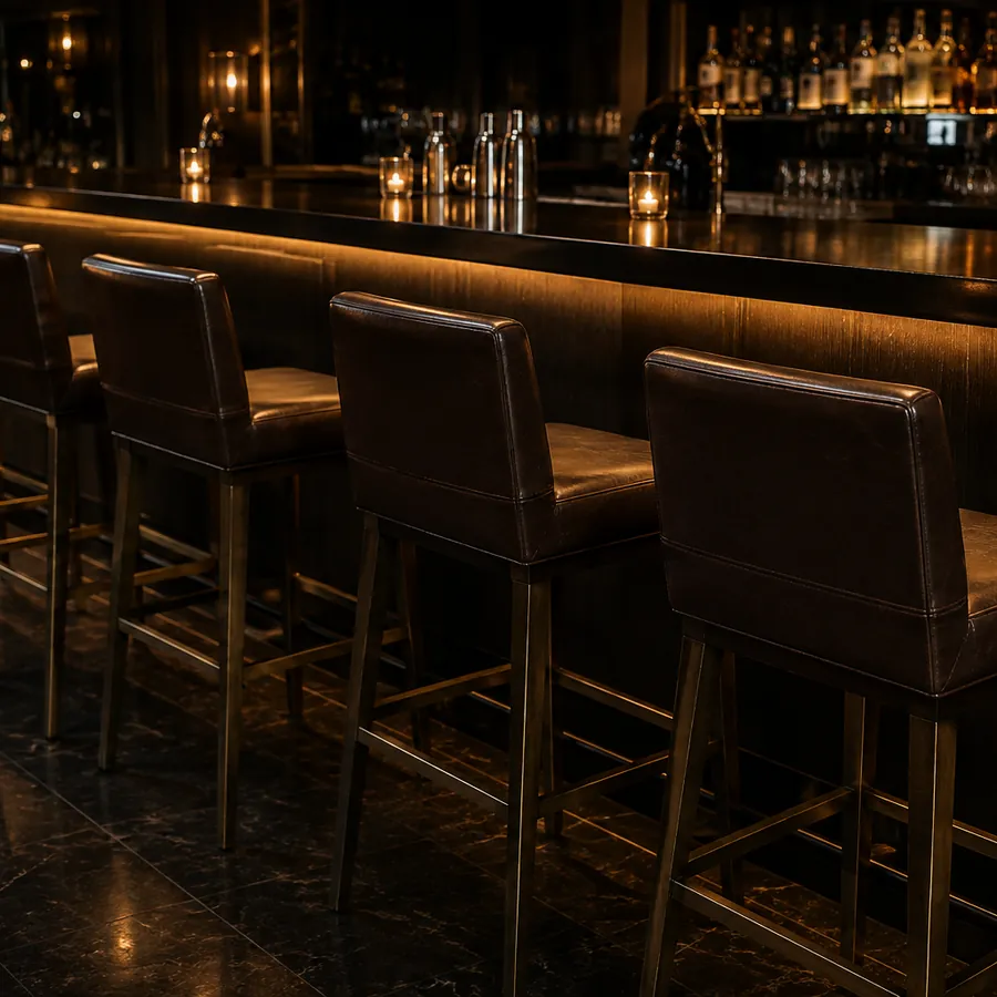 A row of upholstered bar stools along a nightclub bar