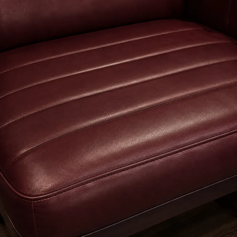 Horizontal channels across a burgundy leather club chair seat