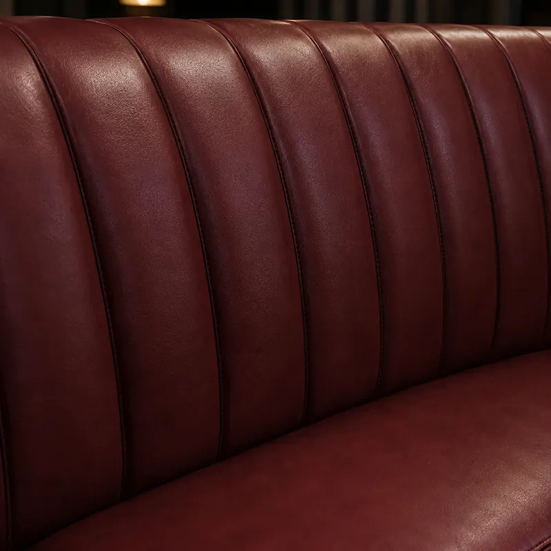 Vertical channel stitching on a burgundy leather banquette back