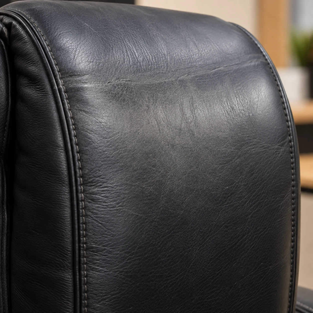 Black office chair back with dulled uneven colour from wear