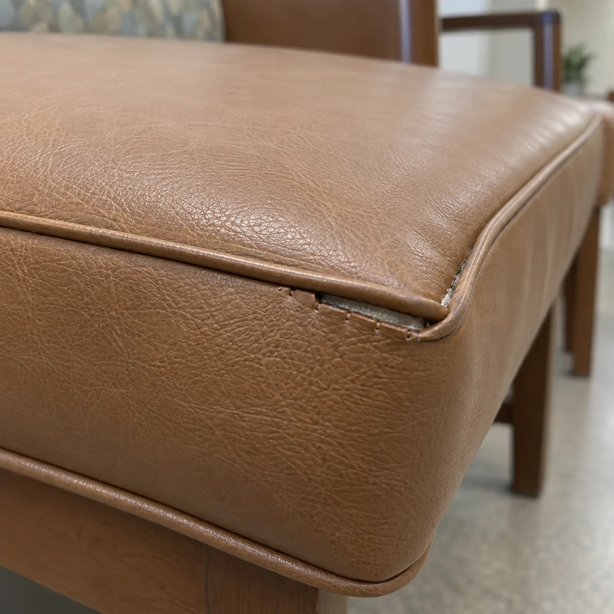 An opened welt seam at the corner of a cognac seat cushion