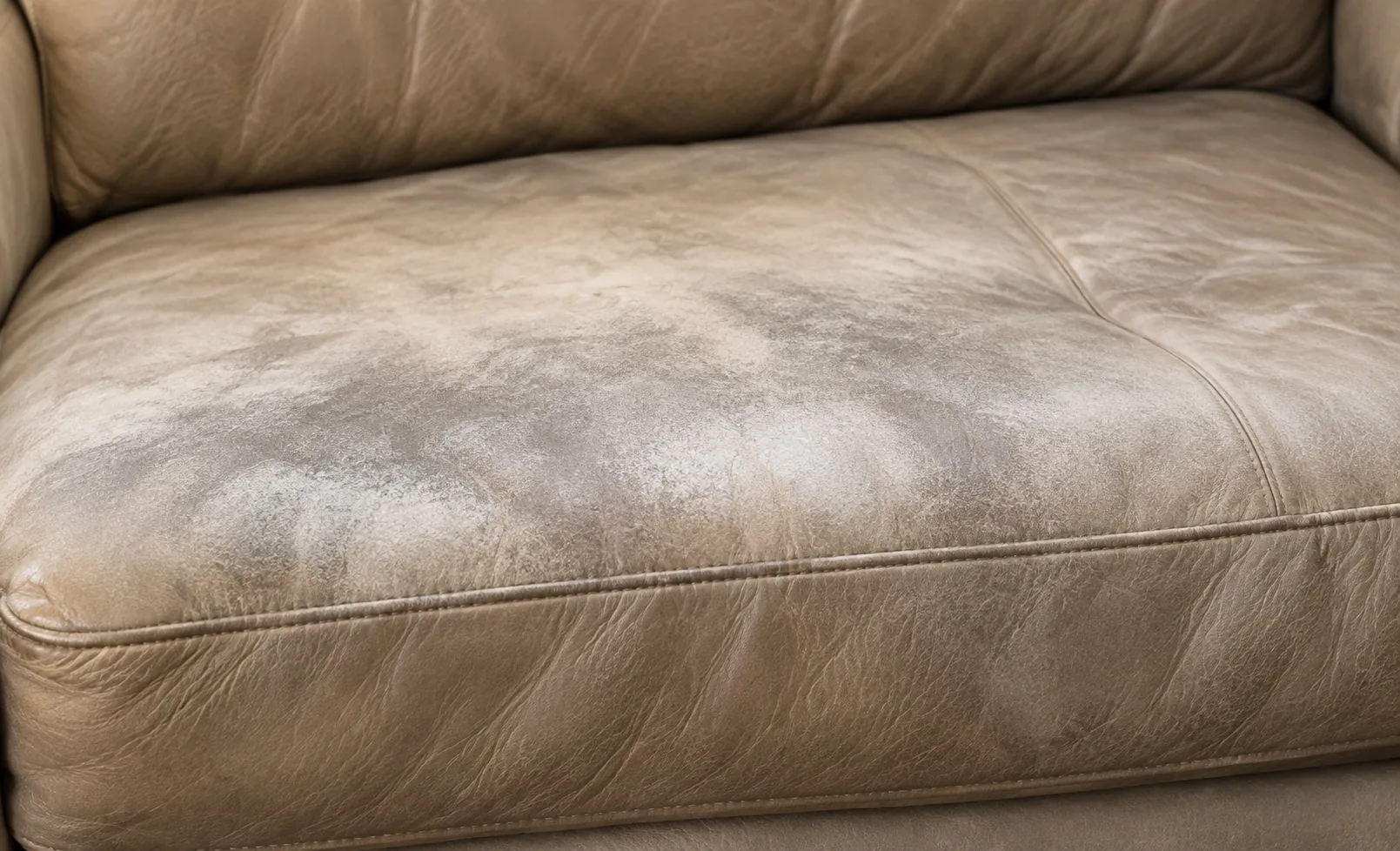 Taupe leather cushion with body soil and colour loss