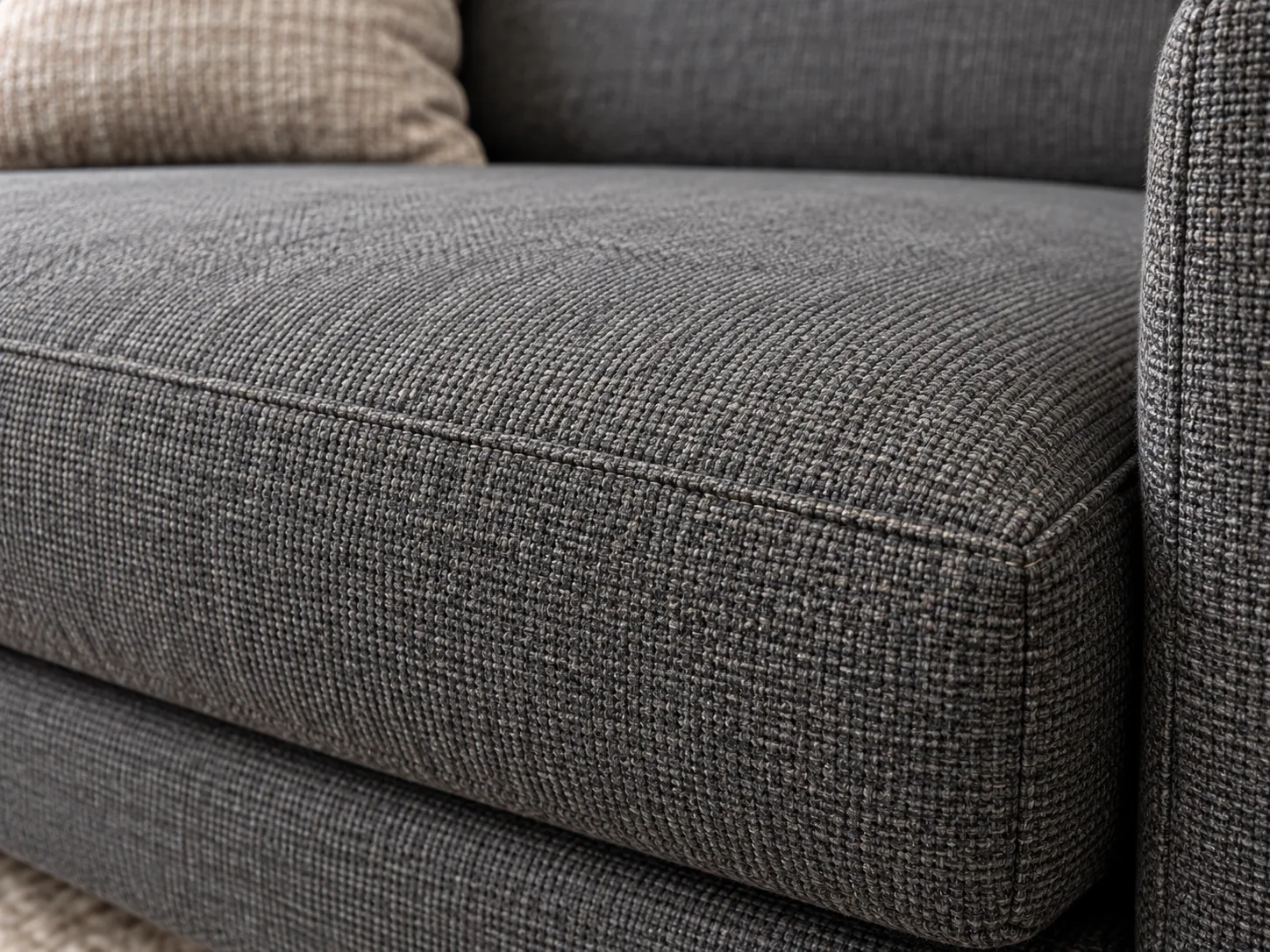 A close-up of charcoal performance fabric on a sofa cushion