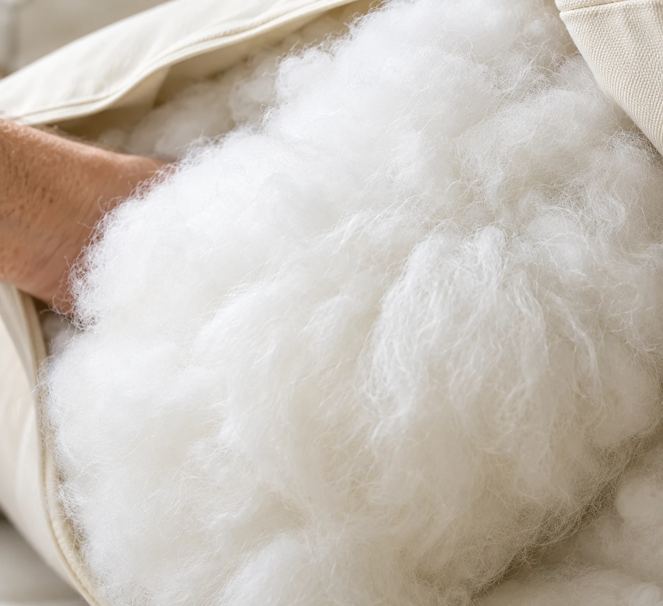 Hand filling a cushion with fiber wrap