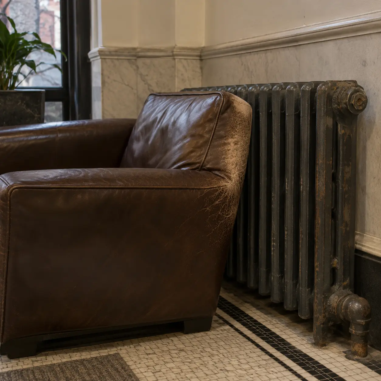 A leather lounge chair pushed against a hot radiator