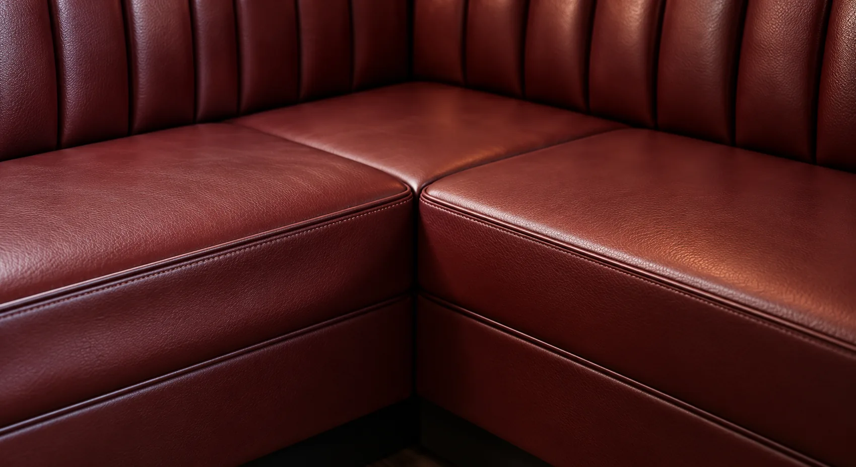 Two red leather banquette seat decks meeting at a corner joint