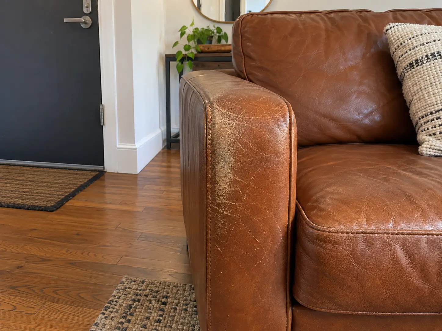 Scuffed arm on a cognac leather sofa