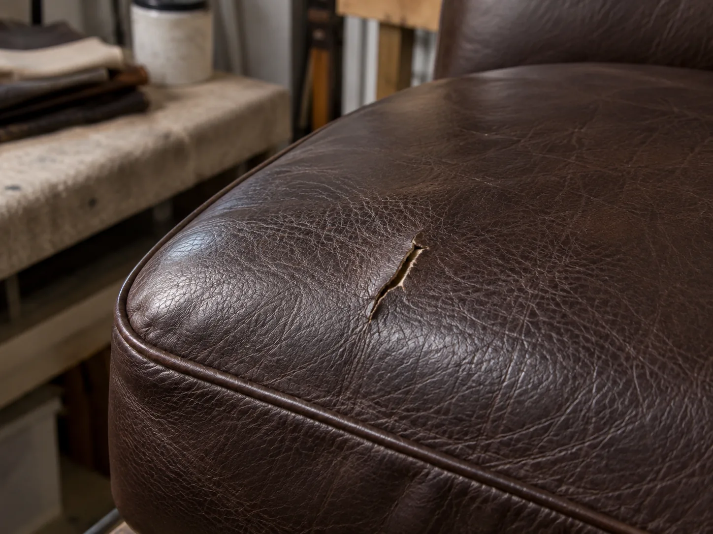 Small tear in a dark leather cushion