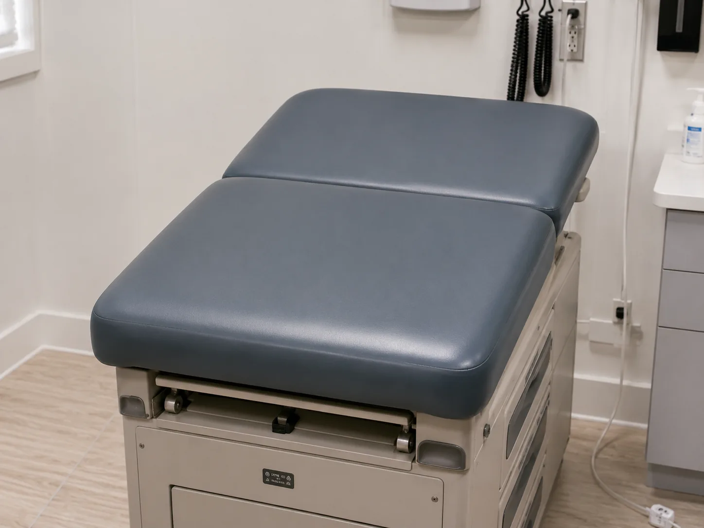The seat and back pads of an exam table newly recovered in slate vinyl