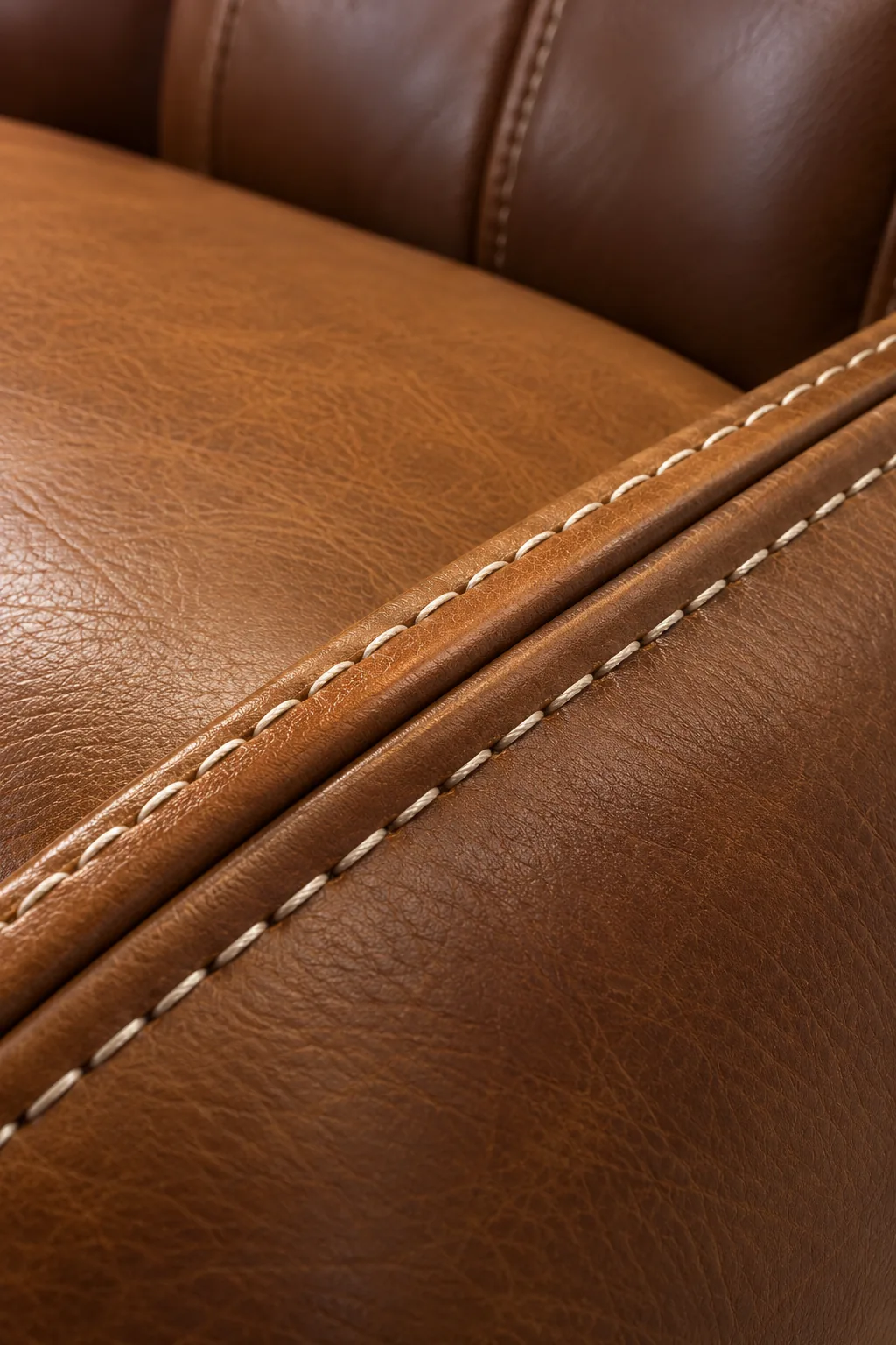 Twin rows of tan contrast stitching running along the corner of a brown leather seat