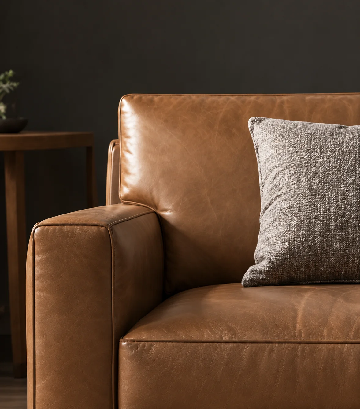 Tan leather sofa with a gray pillow