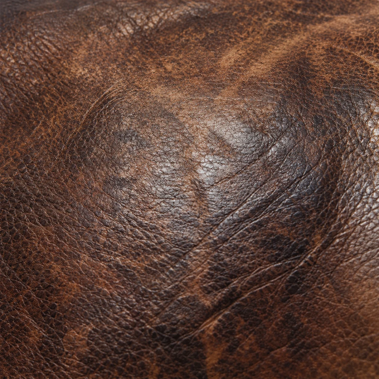 Mottled wear on a brown leather panel