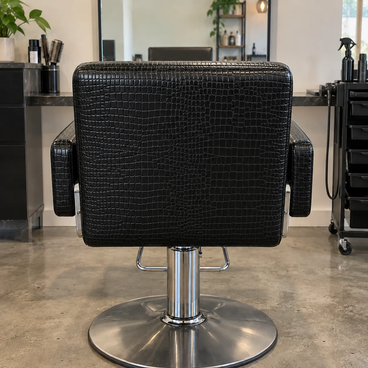 A styling chair covered in croc-embossed black vinyl