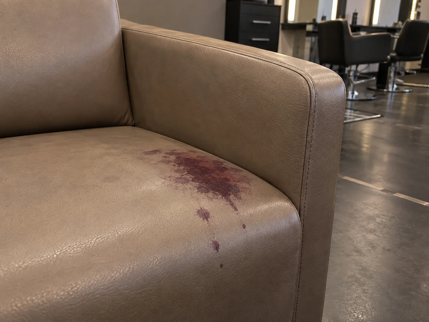 Hair dye stain on a taupe salon chair seat