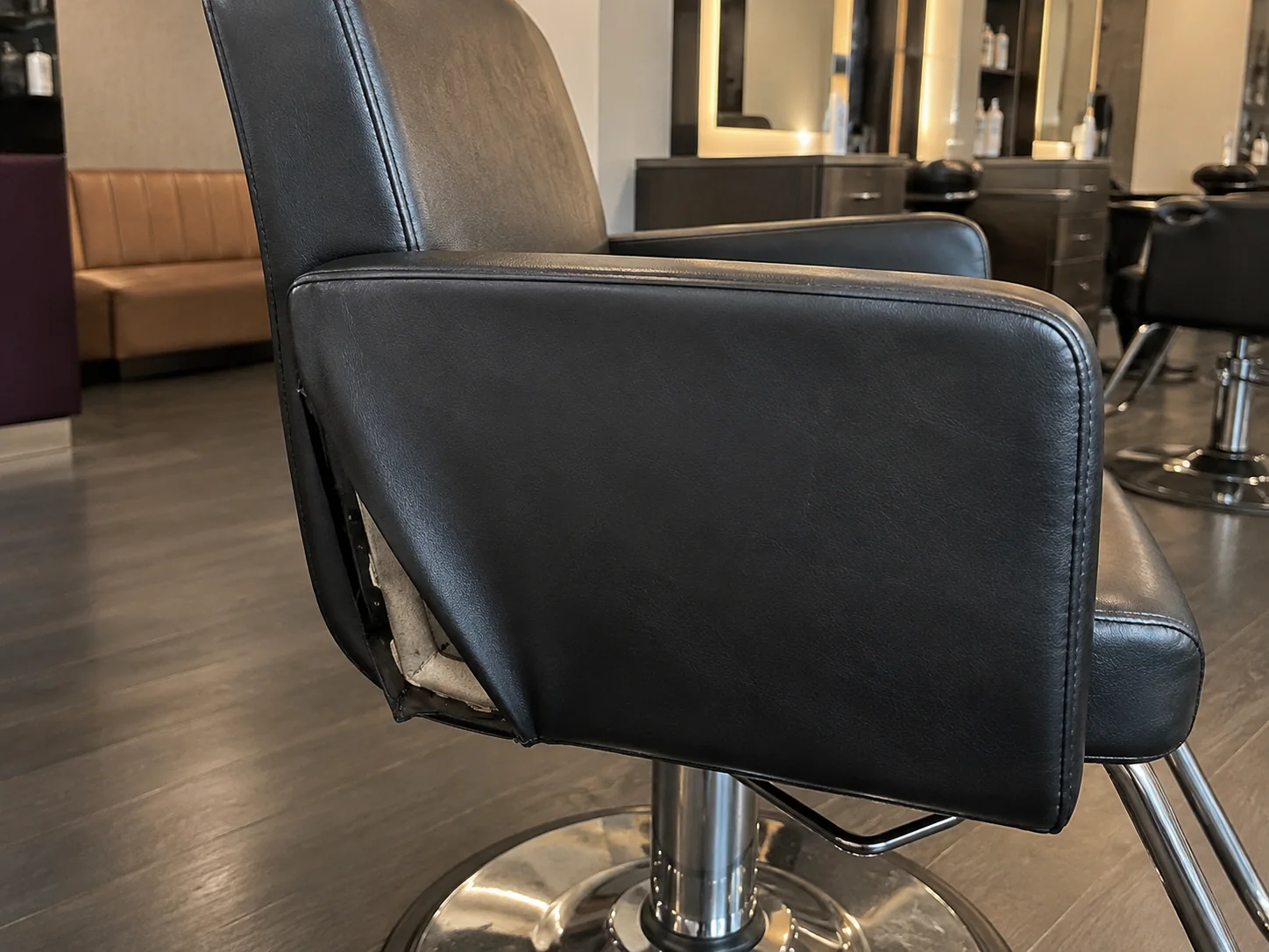 A loose side panel pulling away from a salon chair