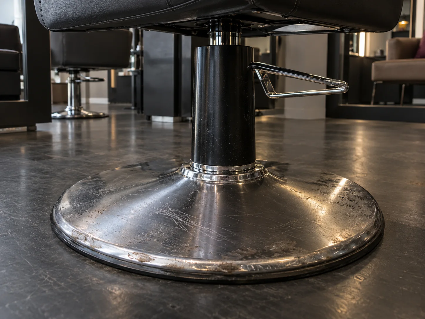 Scratched chrome base of a salon styling chair