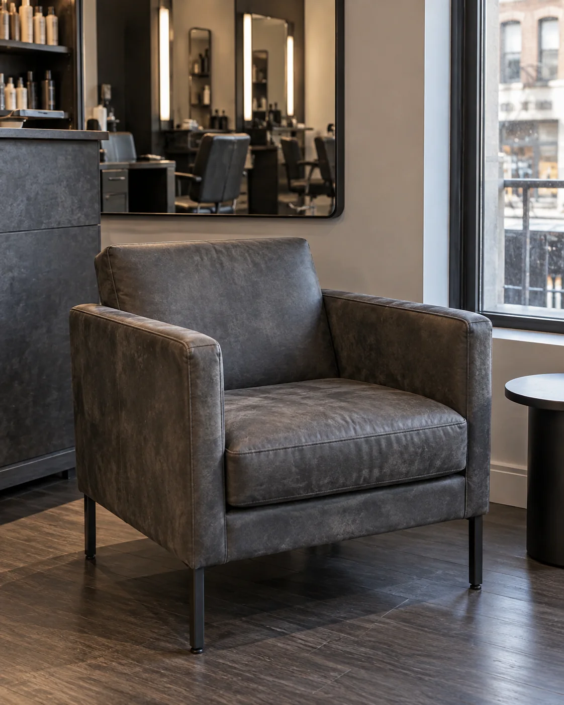 Grey leather waiting armchair by a salon window