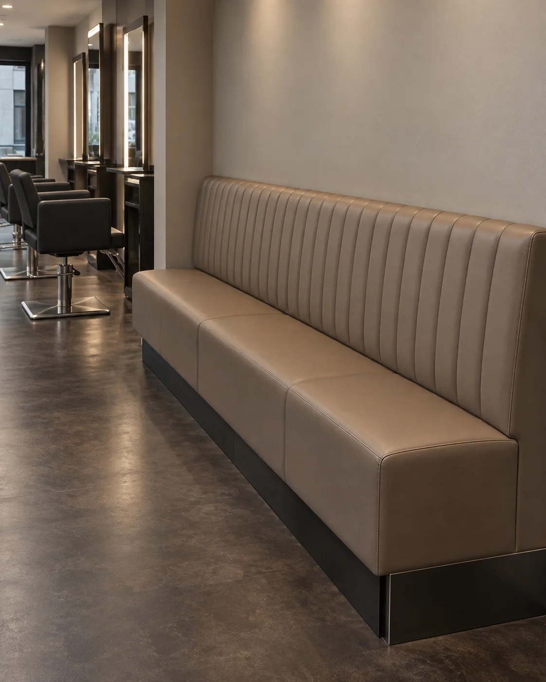 A channel-stitched taupe wall banquette along a salon waiting area