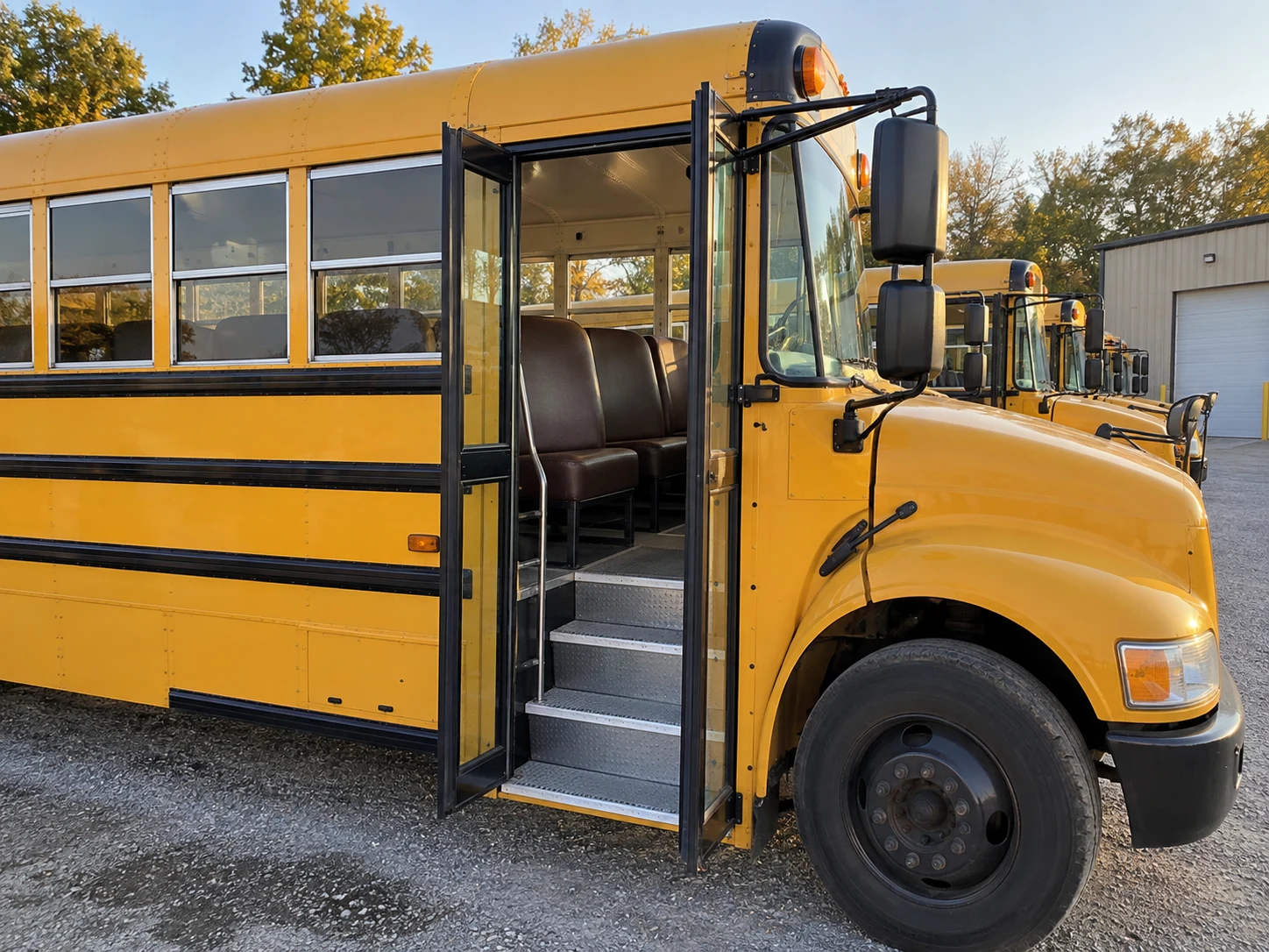 A school bus back in the yard line with new seats inside